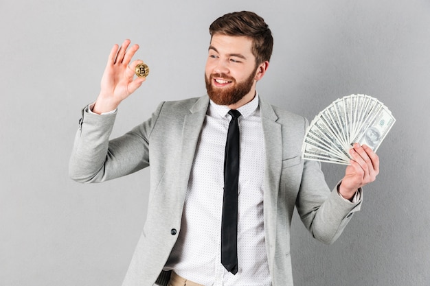 Portrait of a happy businessman showing bitcoin