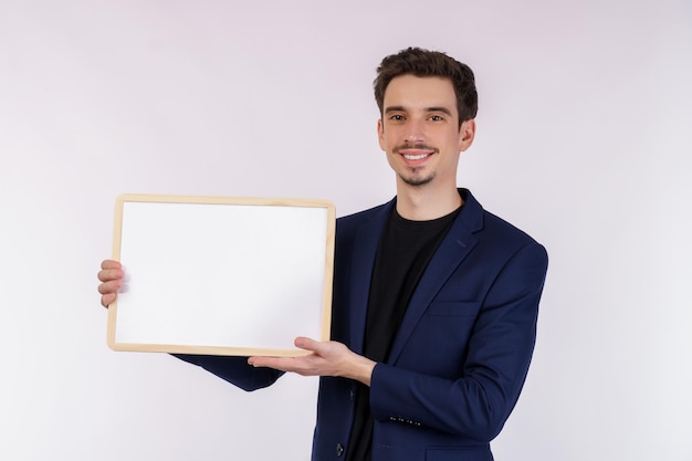 Portrait of happy businessman showing blank signboard on isolated white background