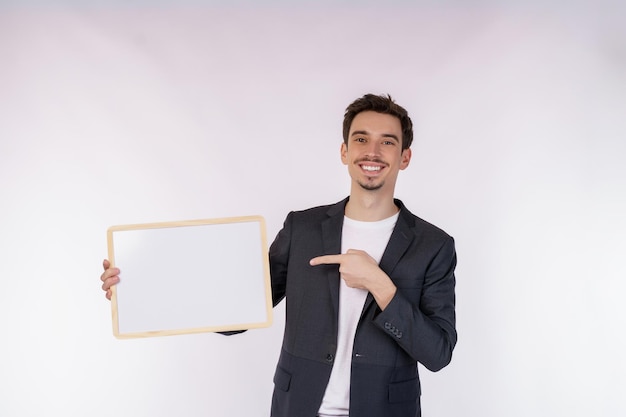 Portrait of happy businessman showing blank signboard on isolated white background