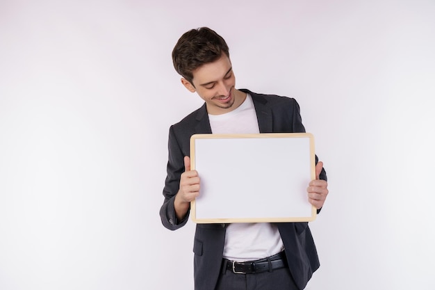 Portrait of happy businessman showing blank signboard on isolated white background