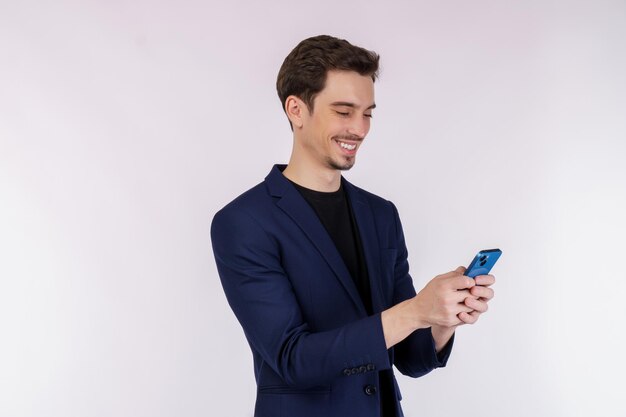 Портрет счастливого бизнесмена с помощью смартфона на белом фоне