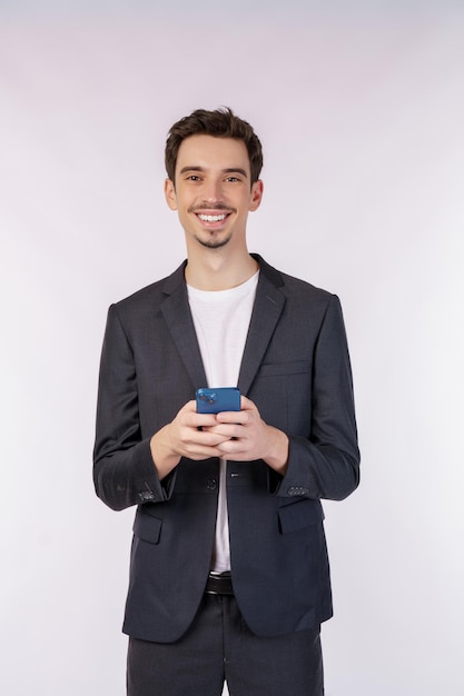 Portrait of a happy businessman using smartphone over white background