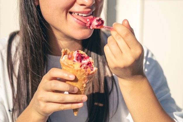 Portrait of happy caucasian brunette woman eating icecream cone