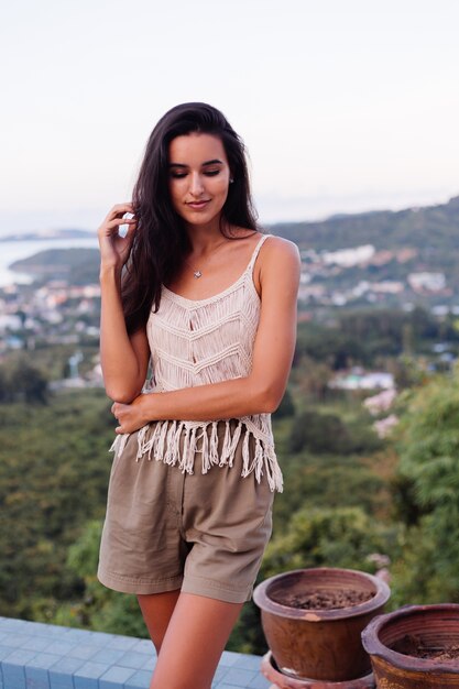 Portrait of happy caucasian calm romantic woman in casual look with long hair wearing earings and necklace on background amazing beautiful view on green mountains