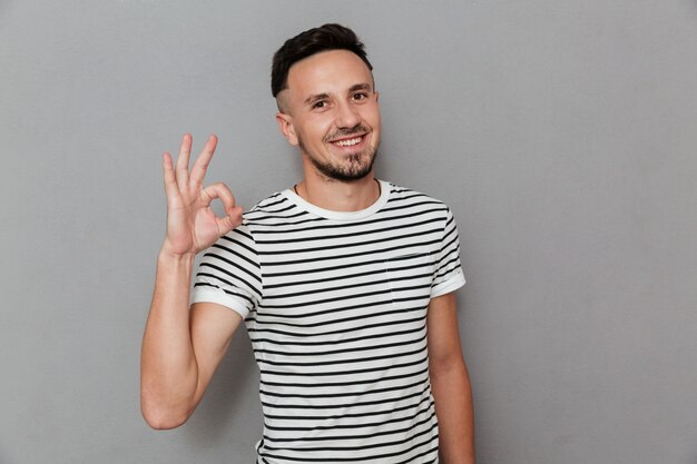 Portrait of a happy cheerful man showing ok gesture