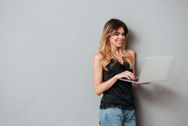 Portrait of a happy cheerful woman using laptop computer