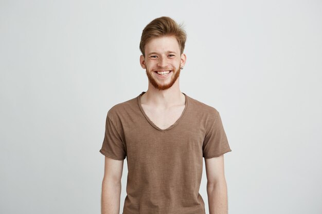 Portrait of happy cheerful young man with beard smiling.