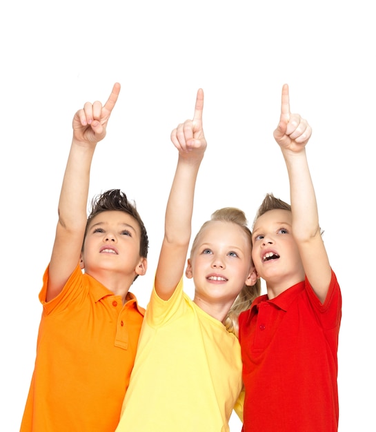 Portrait of the happy children point up by fingers on something away -  isolated on white