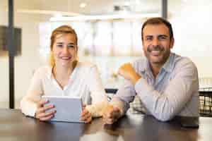 Free photo portrait of happy colleagues sitting at cafe during break