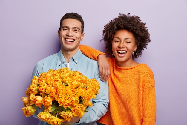 Portrait of happy couple and bouquet of flowers
