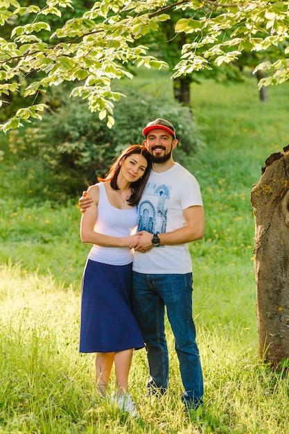 Foto gratuita ritratto di coppia felice abbracciando in giardino