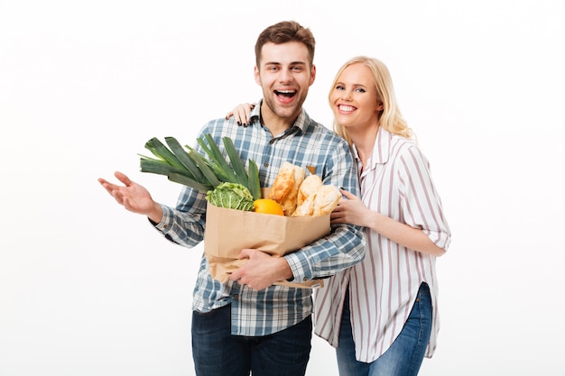 Portrait of a happy couple holding paper shopping bag