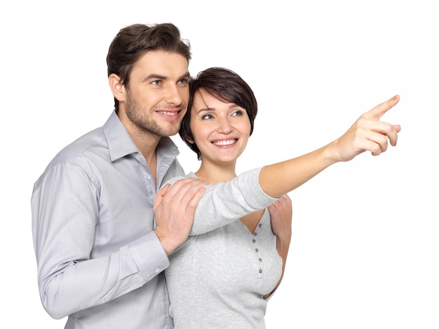 Portrait of the happy couple looking and pointing into the distance, .