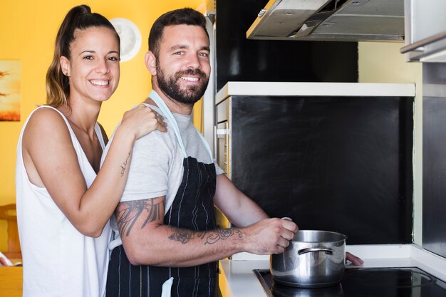 Portrait of a happy couple preparing food in kitchen