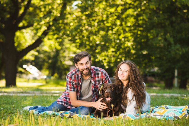 Портрет счастливая пара с их собакой в ​​парке