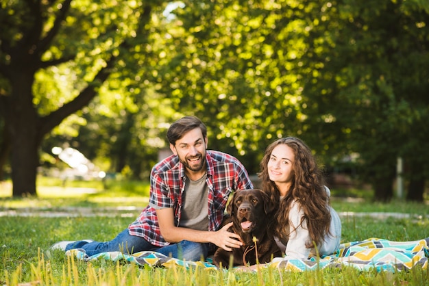 公園で犬と幸せな夫婦の肖像画