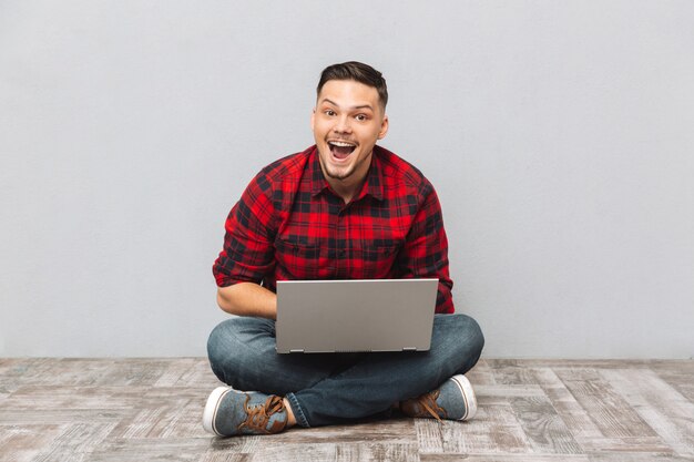 Portrait of a happy excited man in plaid shirt working