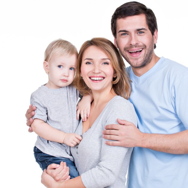 Портрет счастливой семьи с маленьким ребенком, смотрящим в камеру - изолированные