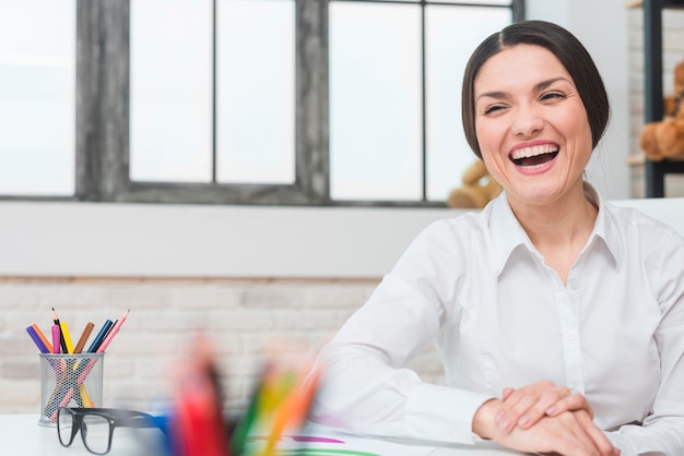 Portrait of happy female psychologist laughing in the office