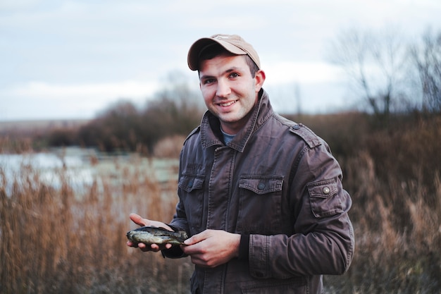 Portrait of a happy fisherman holding fish