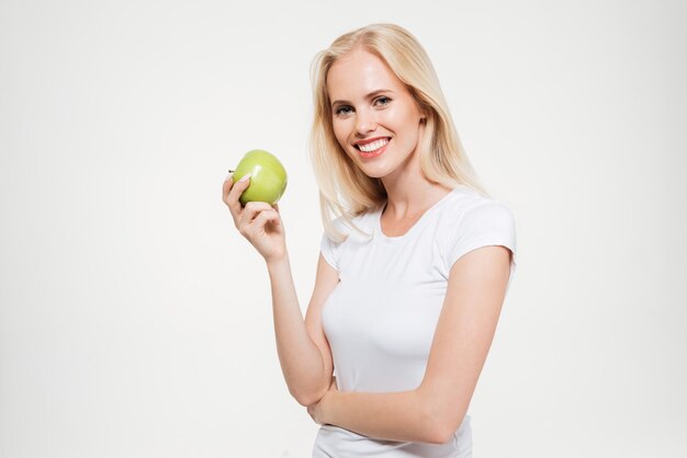 Портрет счастливой женщины, держащей зеленое яблоко