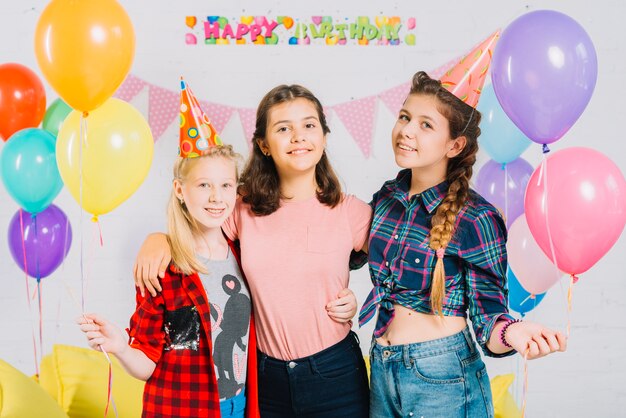 Portrait of happy friends holding colorful balloons