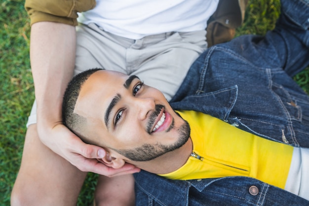 Portrait of happy gay couple spending time together and having a date at the park. Lgbt and love concept.