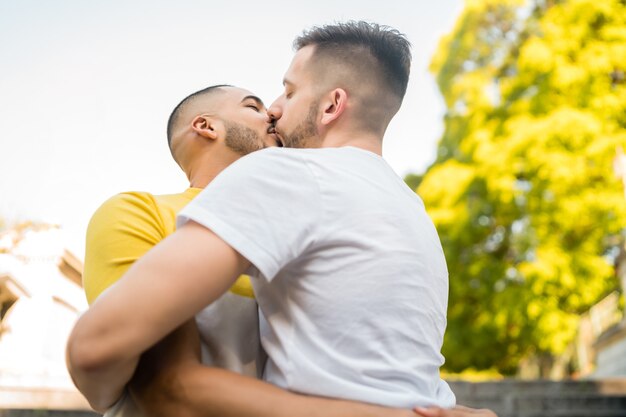 Portrait of happy gay couple spending time together and having a date at the park