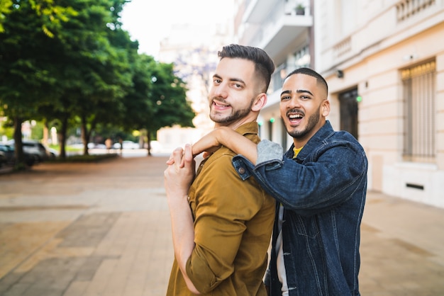 Portrait of happy gay couple spending time together and hugging in the street. Lgbt and love concept.