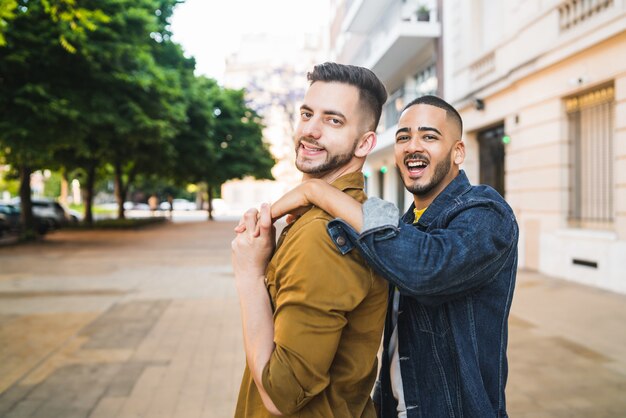 一緒に時間を過ごし、通りで抱き締める幸せな同性愛者のカップルの肖像画。 LGBTと愛の概念。
