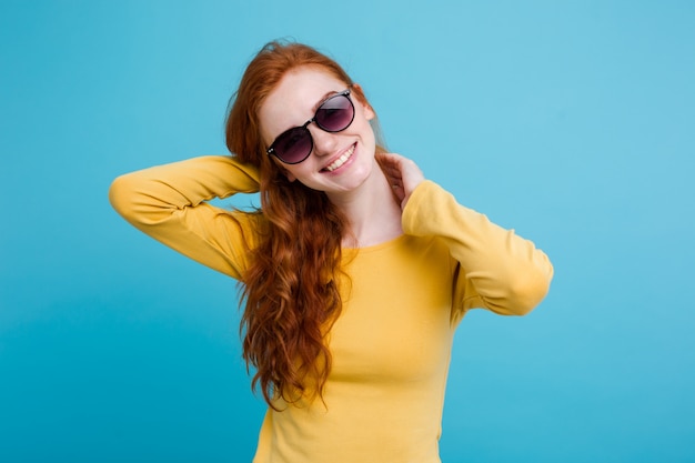 Портрет счастливый рыжий рыжий волосы девушка с веснушками, улыбаясь, глядя на камеру. Пастель синий фон. Копирование пространства.