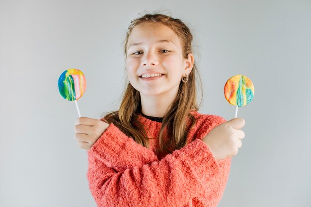 Portrait of a happy girl holding lollipops