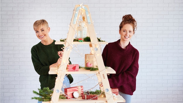 Free photo portrait of happy girls decorating the christmas tree