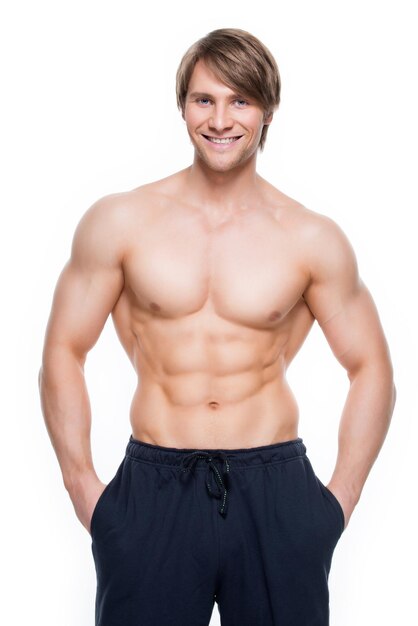 Portrait of a happy handsome man with muscular torso - isolated on white wall.