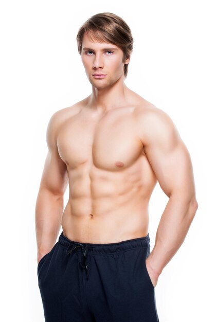 Portrait of a happy handsome man with muscular torso - isolated on white wall.