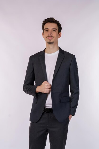 Portrait of happy handsome young man in suit posing on isolated background