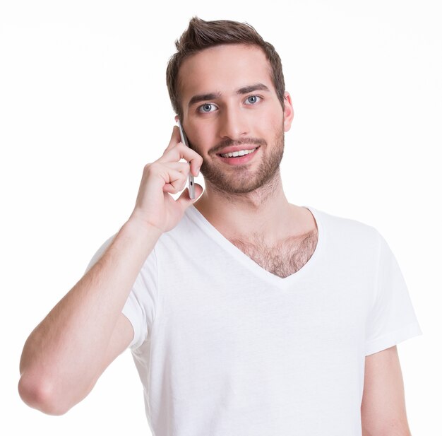 カジュアルに携帯電話で呼び出す幸せな男の肖像画-白で隔離。コンセプトコミュニケーション。