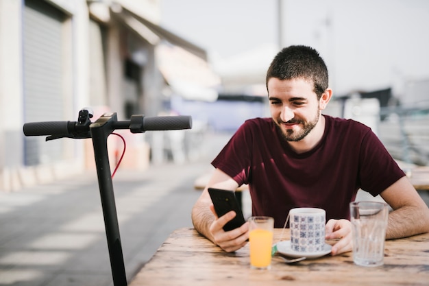 Portrait of a happy man next to an e-scooter