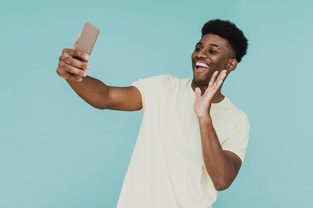 Portrait of happy man having a video call with smartphone