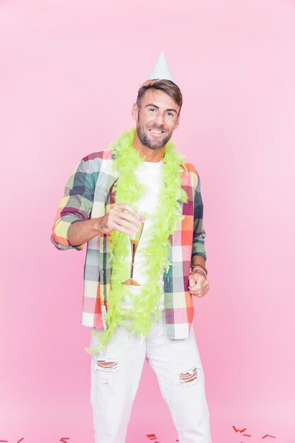 Portrait of a happy man holding wineglass on pink background