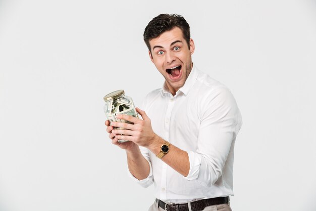 Portrait of a happy man in shirt holding glass jar