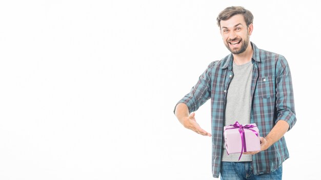Portrait of a happy man showing birthday gift on white background