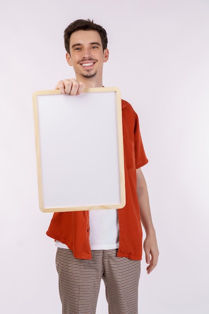 Ritratto di uomo felice che mostra cartello in bianco su sfondo bianco isolato