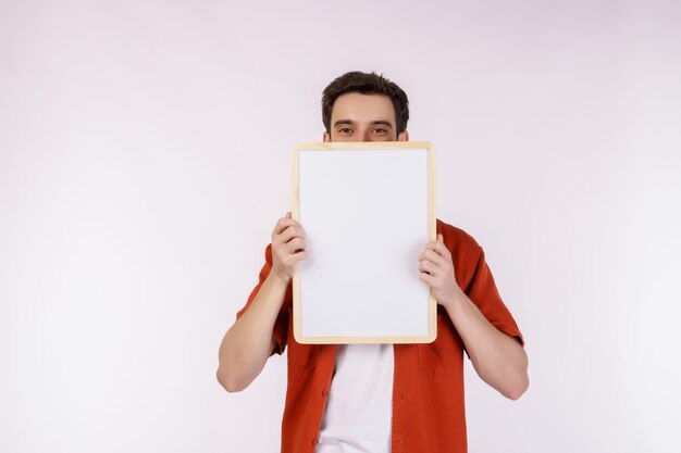 Portrait of happy man showing blank signboard on isolated white background