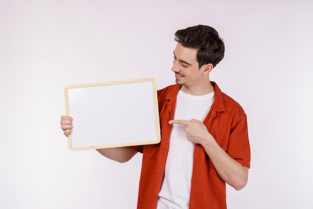 Portrait of happy man showing blank signboard on isolated white background