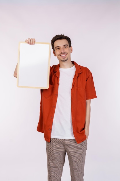 Portrait of happy man showing blank signboard on isolated white background