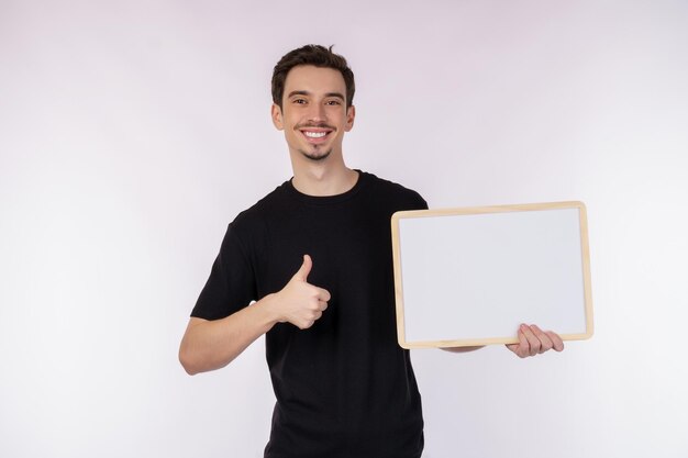 Portrait of happy man showing blank signboard on isolated white background