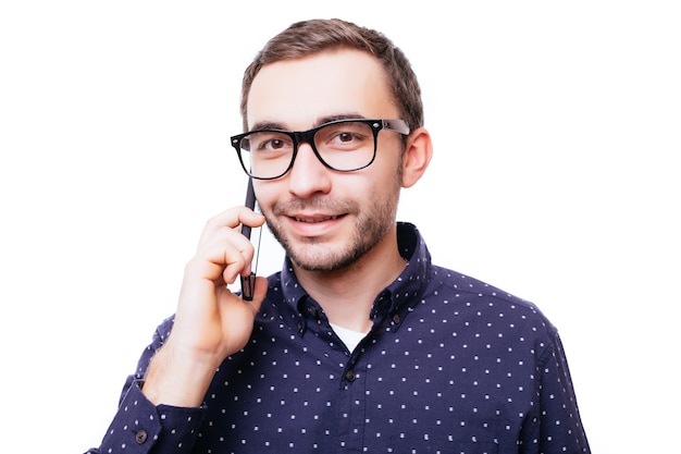 Портрет счастливого человека, разговаривающего по телефону, изолированного на белой стене