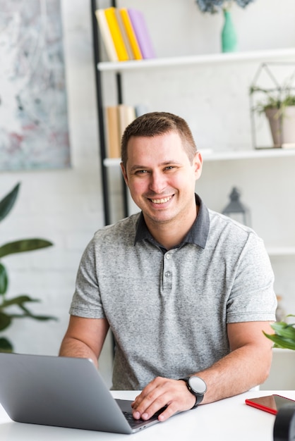 Portrait of a happy man with laptop on desk