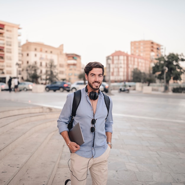 Foto gratuita ritratto di un uomo felice con il portatile